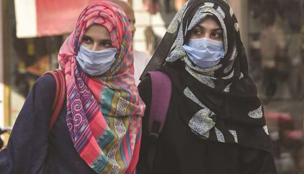 Women wearing face masks as a preventative measure against the coronavirus are seen at a market in Lahore.