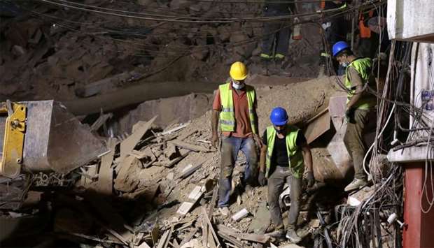 Lebanese civil defence members dig through the rubble of buildings which collapsed by the explosion at the city's port area, after signs of life were detected, in Gemmayze, Beirut
