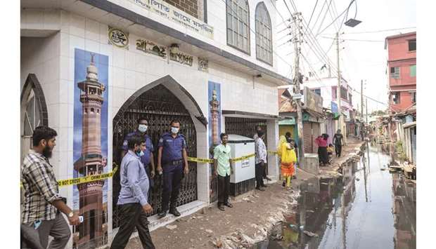 Police personnel stand guard in front of a mosque, following a fire accident, in Narayanganj.