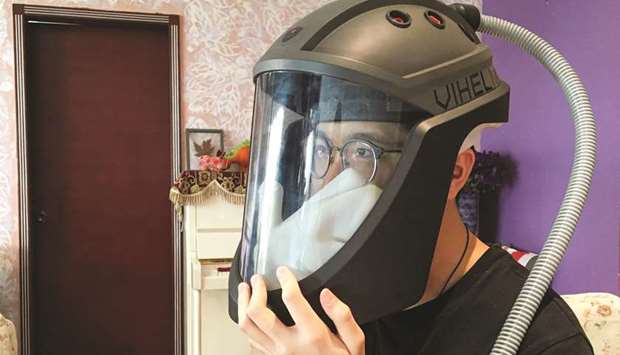 Student Do Trong Minh Duc, 16, wears a prototype helmet named Vihelm, which he designed to protect nurses and doctors from contracting the coronavirus disease at hospitals, in Hanoi.
