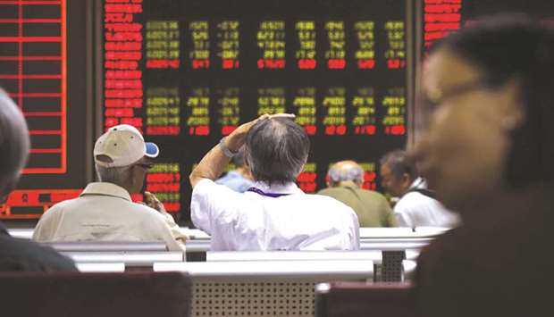 Investors watch stock market movements at a securities company in Beijing. The Composite closed down 1.9% to 3,254.63 points yesterday.