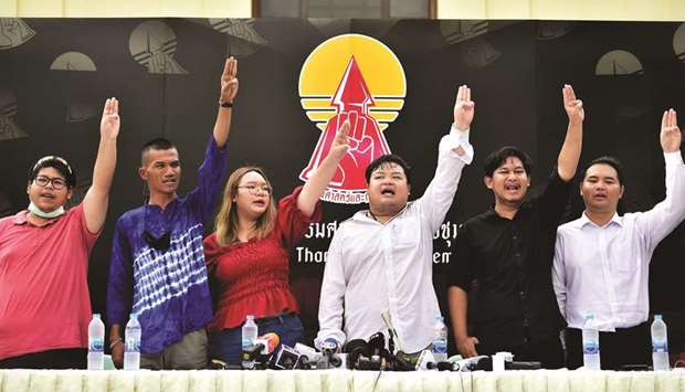 Student leaders from the United Front of Thammasat and Demonstration give the three-fingered Hunger Games salute during a press conference at Thammasat University in Bangkok yesterday.