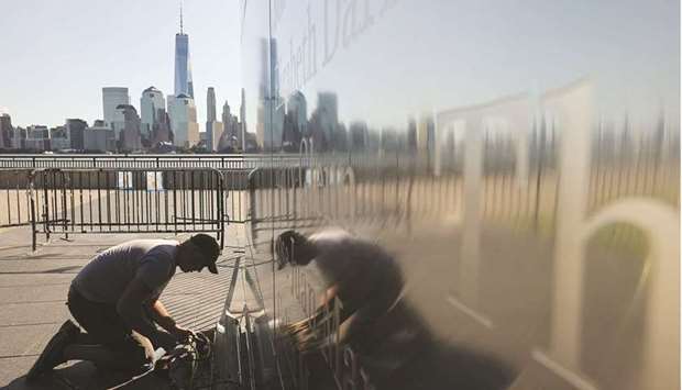 An electrician works yesterday to replace broken lights at the base of Empty Sky, the official New Jersey memorial to the stateu2019s victims of the September 11, 2001 attacks, the day before the annual commemoration at Liberty State Park across the Hudson River from Manhattan, in Jersey City. Of the 2,977 victims of the September 11 attacks at the World Trade Centre, the Pentagon, and on Flight 93, 749 were from New Jersey.