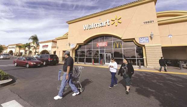 Customers walk outside a Walmart store in the Porter Ranch section of Los Angeles (file). American consumersu2019 hopes of completely and quickly escaping the clutches of Covid-19 have been dashed by a more contagious variant, renewed mask mandates and uncertainty surrounding in-person returns to schools.