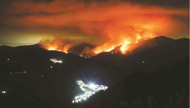 A wildfire is seen at night on Sierra Bermeja Mountain, near the towns of Genalguacil (left) and Benarraba (bottom), in southern Spain, in this picture taken with a long exposure.