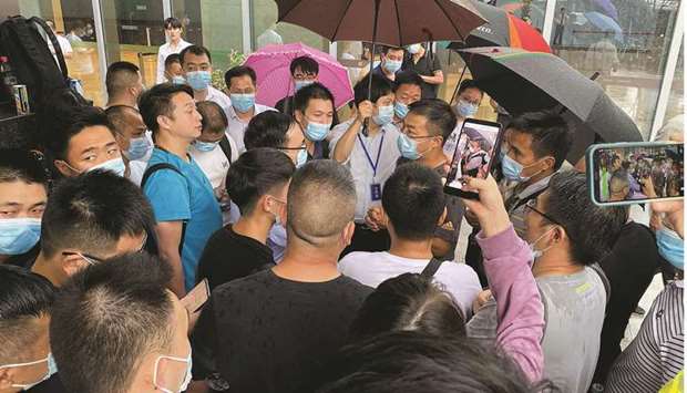People gather outside the Evergrande headquarters in Shenzhen, southeastern China, yesterday. Chinau2019s government is assembling a group of accounting and legal experts to examine the finances of China Evergrande Group, a potential precursor to a restructuring of the worldu2019s most indebted developer.