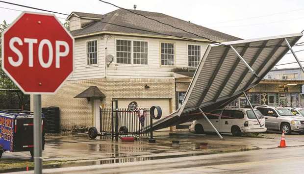 A carport hangs from power-lines after Tropical Storm Nicholas moved through the area in Houston, Texas, yesterday.