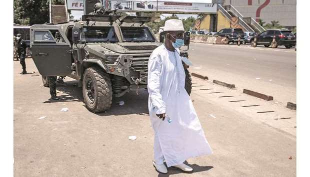 A man walks in front of an armoured military vehicle after the first session of talks between Colonel Mamady Doumbouya and current Guinean political parties in Conakry, yesterday.