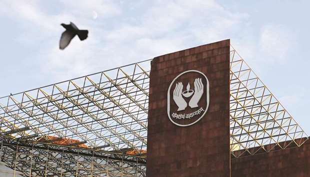 A bird flies past a logo of Life Insurance Corporation of India at one of its offices in New Delhi (file). With millions of policyholders and a share of 66% of new premium collections in a crowded insurance market, LIC is a household name, managing assets of more than $450bn.