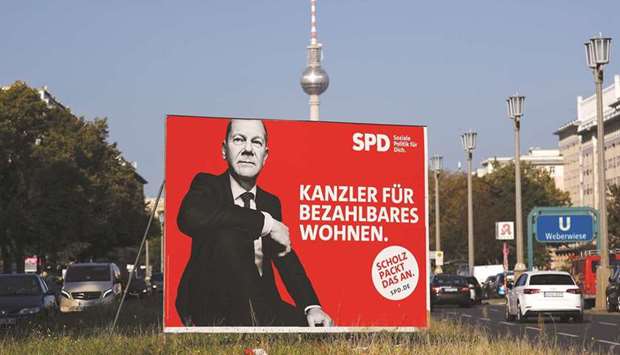 Vehicles pass by an election poster showing Olaf Scholz, German Minister of Finance and top candidate of the The Social Democratic Party of Germany (SPD) in Berlin. Scholz is currently the frontrunner to become chancellor, but itu2019s a tight race and the make-up of the government will depend on coalition discussions, which are likely to take months.