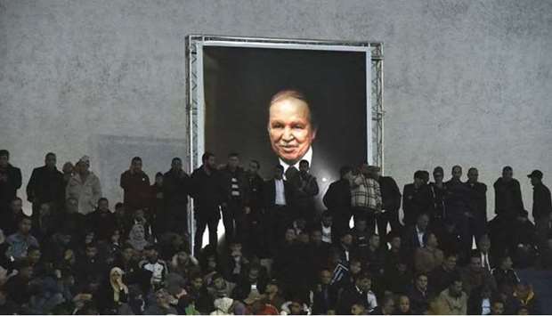 In this file photo taken on February 9, 2019 Supporters of Algeria's National Liberation Front (FLN) party, gather at La Coupole arena in the capital Algiers to call upon the current President Abdelaziz Bouteflika (poster) to run for a fifth term in office.