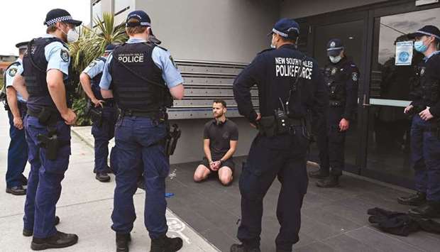 Police detain a man after checking his identification in Sydney following calls for an anti-lockdown protest rally amid the coronavirus pandemic.