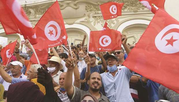 Tunisian demonstrators shout slogans against President Kais Saied during a protest in the capital Tunis, yesterday. Below: Demonstrators gesture and shout slogans as they gather in support of Tunisiau2019s president in Tunis.