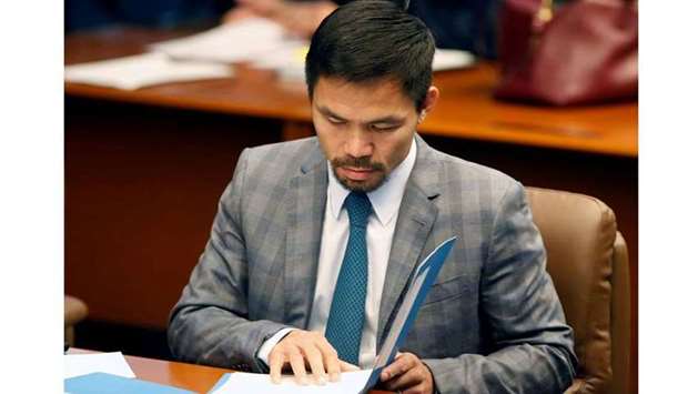 Philippine Senator and boxing champion Manny Pacquiao reads his briefing materials as he prepares for the Senate session in Pasay city, Metro Manila, Philippines September 20, 2016. REUTERS/Erik De Castro/File Photo