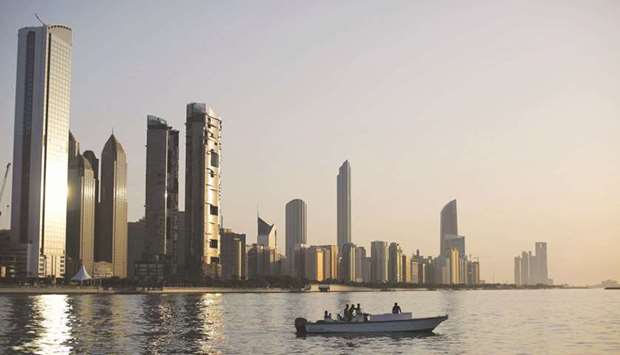 A general view of the city skyline at sunset from Dhow Harbour in Abu Dhabi (file). The $110bn state holding company ADQ has hired scores of investment bankers from Western banks in the past year as it accelerates dealmaking in the United Arab Emirates and overseas, three sources familiar with the matter said.