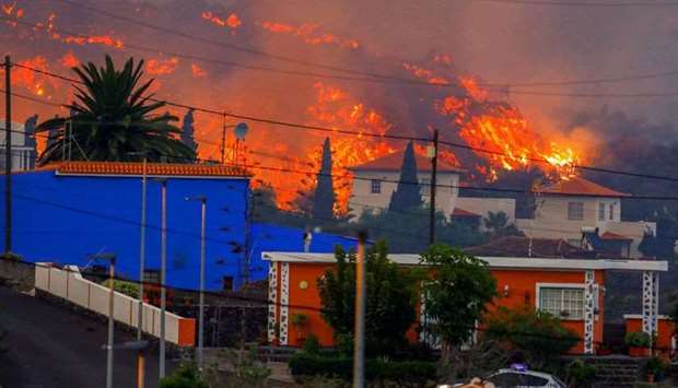 Lava flows behind houses following the eruption of a volcano in the Cumbre Vieja national park at Los Llanos de Aridane, on the Canary Island of La Palma.