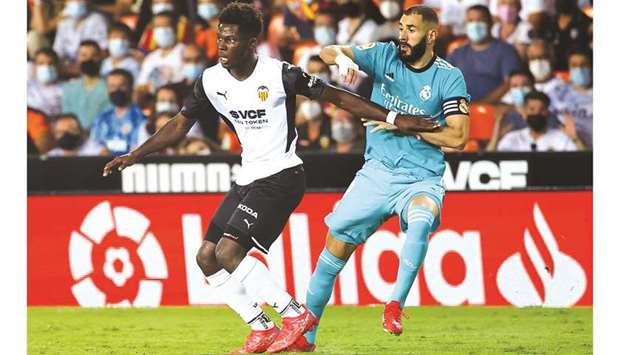 Real Madridu2019s Karim Benzema (right) vies for the ball with Valenciau2019s Yunus Musah during the La Liga match on Sunday. (AFP)