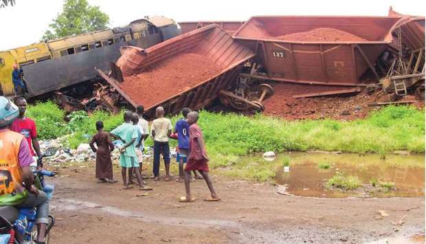 People watch bauxite trains, operated by Russian aluminium giant Rusal, which collided in Wanindara neighbourhood of Conakry, Guinea, yesterday.
