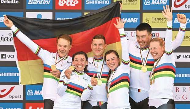 German team members (from left) Nikias Arndt, Lisa Brennauer, Tony Martin, Lisa Klein, Max Walscheid and Mieke Kroeger celebrate on the podium after winning the team time trial mixed relay on the fourth day of the UCI World Championships Road Cycling Flanders 2021 in Bruges yesterday. (AFP)