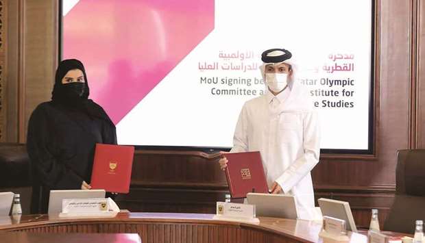 QOC Secretary-General HE Jassim bin Rashid al-Buenain (right) and Doha Institute for Graduate Studies Executive Director of Administration and Finance Mariam bint Ali Nasser al-Misnad pose after signing the MoU.