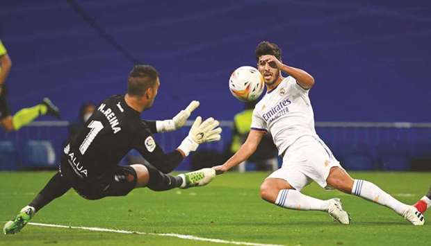 Real Madridu2019s Spanish midfielder Marco Asensio (right) scores his teamu2019s third goal during the Spanish League match against Real Mallorca at the Santiago Bernabeu Stadium in Madrid yesterday. (AFP)