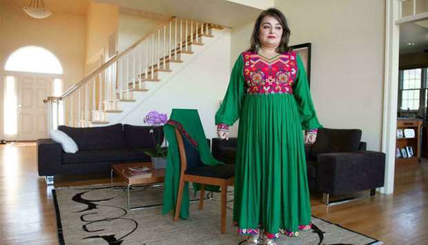 Bahar Jalali, an Afghan-American historian, wears an Afghan traditional dress in her home in Glenwood, Maryland, recently. Jalali, 46, created the social media hashtags #DoNotTouchMyClothes and #AfghanistanCulture. (AFP)