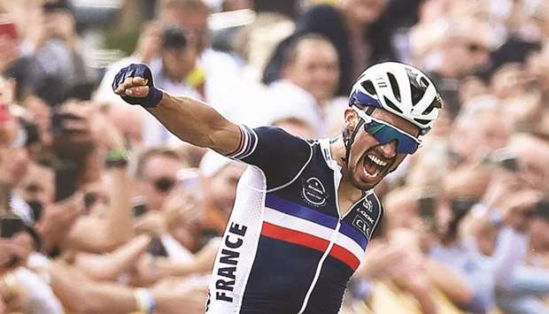 Franceu2019s Julian Alaphilippe celebrates as he crosses the finish line to win the menu2019s elite cycling road race in Leuven on the eighth day of the Flanders 2021 UCI Road World Championships. (AFP)
