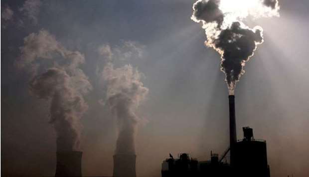 A coal-burning power plant can be seen behind a factory in the city of Baotou, in China's Inner Mongolia Autonomous Region, October 31, 2010. REUTERS
