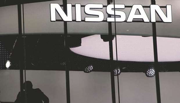 A man is silhouetted at a showroom of Nissan Motor Co in Tokyo (file). Nissan has developed a new technology to halve the cost of recycling rare earths used in magnet motors for electric vehicles, the company said yesterday.