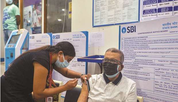 A health worker inoculates an elderly man with the jab of Covishield vaccine against the Covid-19 coronavirus at a branch of State Bank of India in Siliguri yesterday. Activity gauges have missed  expectations in major economies, according to Goldman Sachs Group, while Citigroup warned the recovery could moderate with a deepening divergence between sectors and regions.