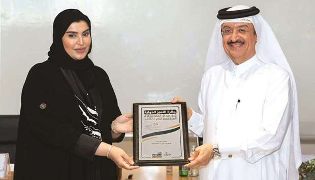 Mariam bint Ali bin Nasser al-Misnad receiving the award from Dr Mohamed bin Saif al-Kuwari.