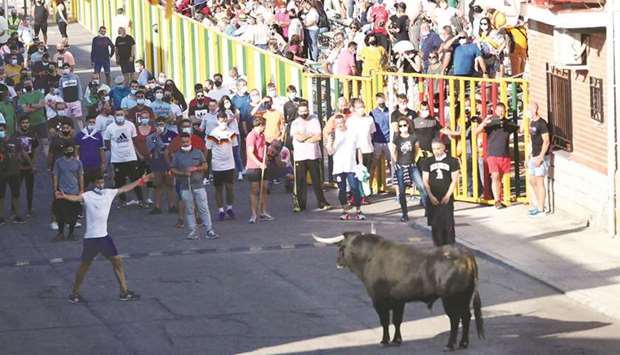 Revellers and spectators watch a steer yesterday during the first running-of-the-bull festival since the coronavirus pandemic began, in Villaseca de la Sagra, central Spain (see report below).
