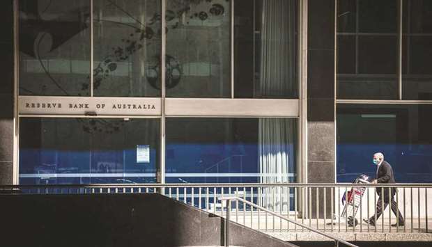 A pedestrian pushes a cart of documents past the Reserve Bank of Australia building in Sydney. The RBA pushed ahead with a cautious winding back of its bond-buying programme, underlining its confidence in the economyu2019s recovery prospects once a longer-than-expected virus wave abates.
