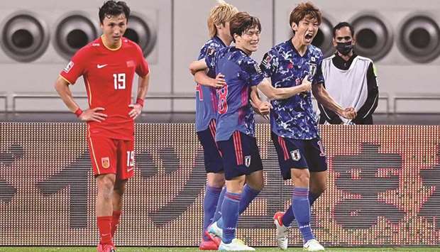 Japanu2019s Yuya Osako (right) celebrates after scoring a goal during the FIFA World Cup 2022 Asian Qualifiers game against China at Khalifa International Stadium yesterday. PICTURE: Noushad Thekkayil