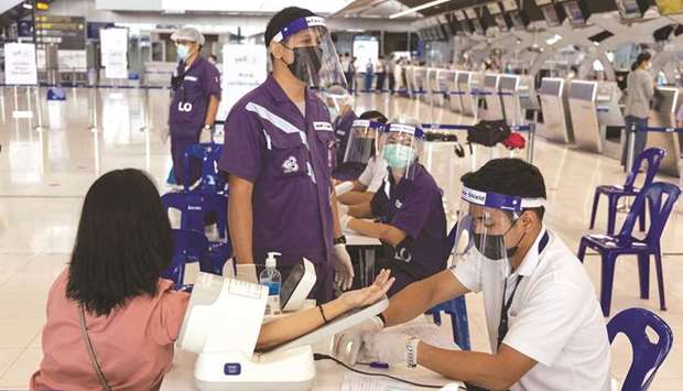 An Airports of Thailand employee has her blood-pressure checked before receiving doses of Covid-19 vaccine, at a vaccination site set up at a near-empty Suvarnabhumi Airport in Bangkok (file). The global airline industry was seeing light at the end of the tunnel following successful rollout of vaccines in many countries, but the Delta variant seems to delay the recovery.