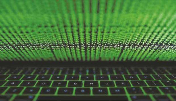 A computer keyboard is lit up by a displayed cyber code