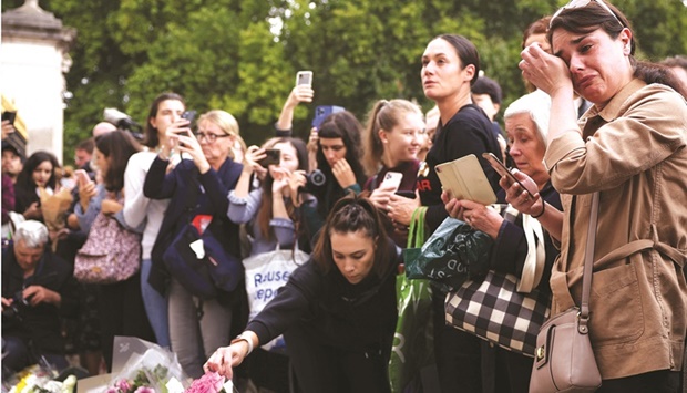 People react outside Buckingham Palace, following the passing of Queen Elizabeth, in London, Britain, yesterday.