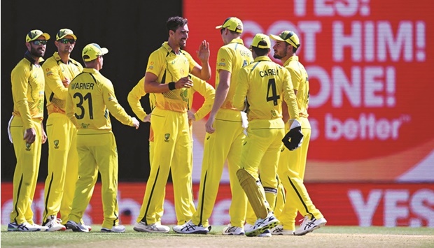 Australiau2019s  Mitchell Starc (centre) celebrates with teammates after dismissing Innocent Kaia during the second one-day international against Zimbabwe at the Riverway Stadium in Townsville yesterday. (AFP)