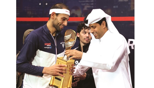 QTerminals Qatar Classic champion Mohamed ElShorbagy of England receives his trophy from Qatar Tennis, Squash and Badminton Federation president Nasser al-Khelaifi at the Khalifa International Tennis & Squash Complex yesterday.
