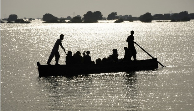 Residents travel in a boat amid flood water, following rains and floods during the monsoon season in village Arazi, in Sehwan, Pakistan Sunday. REUTERS