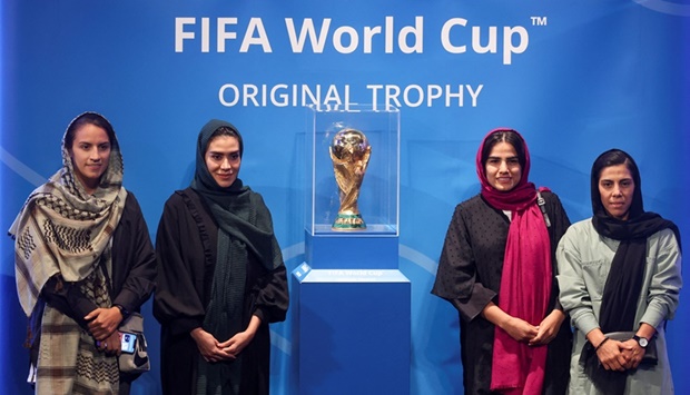 Iran's women footballers pose next to the FIFA World Cup Trophy during an unveiling ceremony in Milad Tower hall in Tehran on Thursday.