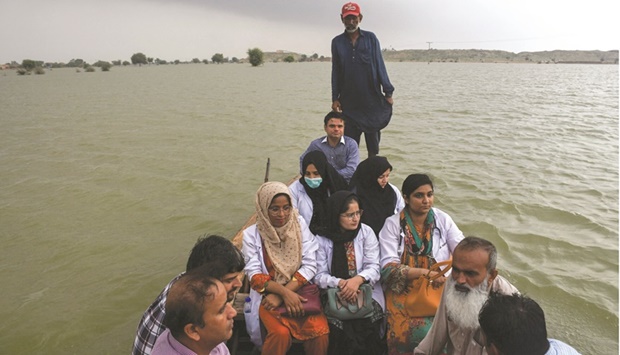 A team of doctors travel to flooded areas in a boat, following rains and floods during the monsoon season, in Manjhand town, in Jamshoro, Pakistan, yesterday. (Reuters)