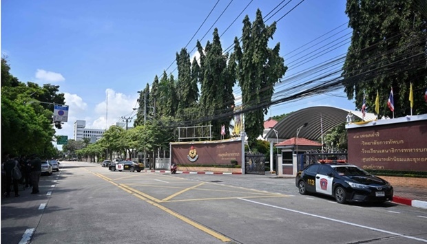 Police cars parked outside the gates after an alleged shooter was detained in the Army Training Command in Bangkok. AFP