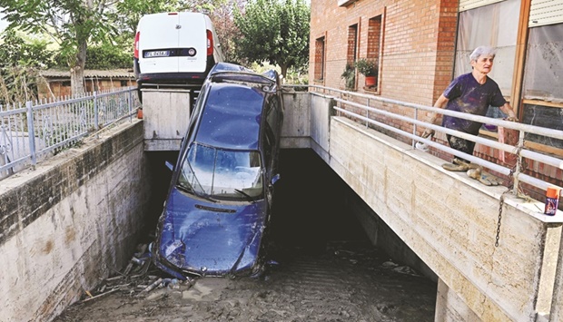 Cars lie damaged following overnight rains in Pianello di Ostra, Ancona province, Italy, yesterday.