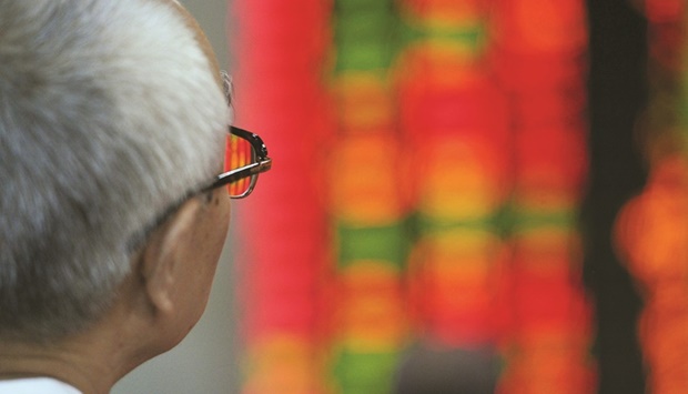 An investor watches stock prices at a securities exchange in Shanghai. The strong Asian showing is mostly down to Chinese IPOs, which have continued to come thick and fast even as rising interest rates and the prospect of a recession put a lid on first-time share sales in most major markets.