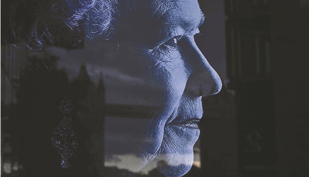 Tower Bridge is reflected on a picture of Britainu2019s Queen Elizabeth II in London yesterday. (AFP)