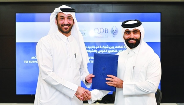 Engineer Ahmad al-Muslemani, Meeza CEO, and Abdulrahman Hesham al-Sowaidi, QDB acting CEO, shaking hands after signing the MoU.