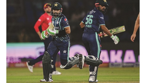 Pakistanu2019s captain Babar Azam (right) and teammate Mohamed Rizwan run between the wicket during the second Twenty20 international against England at the National Cricket Stadium in Karachi yesterday. (AFP)