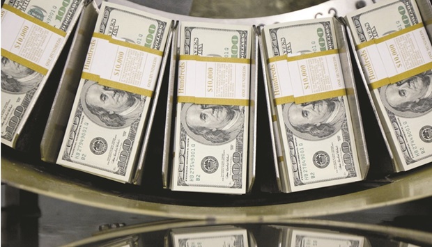 Stacks of dollar bills pass through a circulator machine at the Bureau of Engraving and Printing in Washington, DC. Nations are being forced to go it alone in erecting defences against the relentless strength of the greenback, with no sign that governments are willing to act in concert.