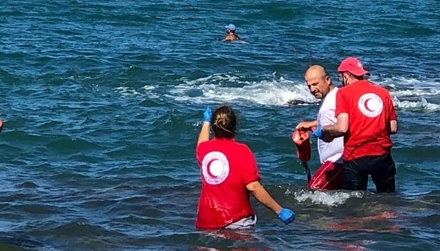 Members of Syrian Red Crescent work at a shoreline following a migrant boat, which according to Lebanese and Syrian officials, sank off the Syrian coast after sailing from Lebanon, in Tartous, Syria. AFP